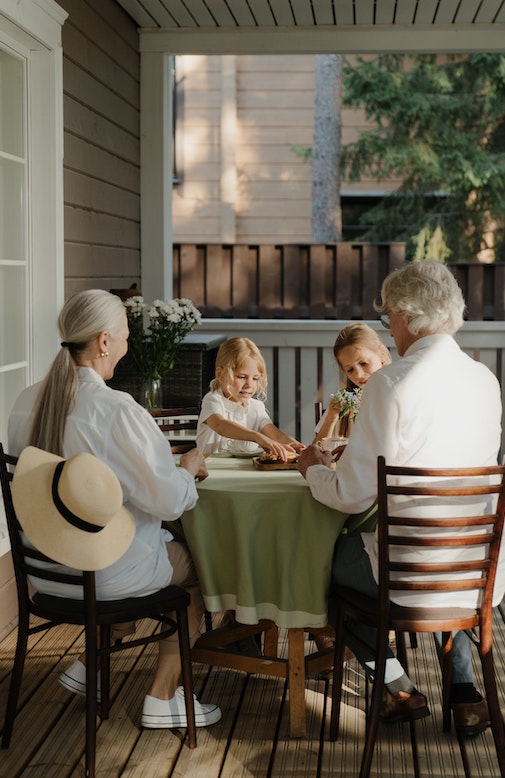 a group 2 elderlies and 2 kids playing tea time together